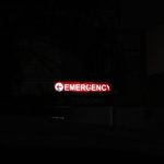 Emergency - a red emergency sign lit up in the dark