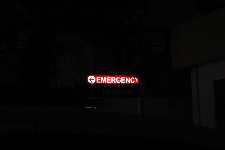 Emergency - a red emergency sign lit up in the dark